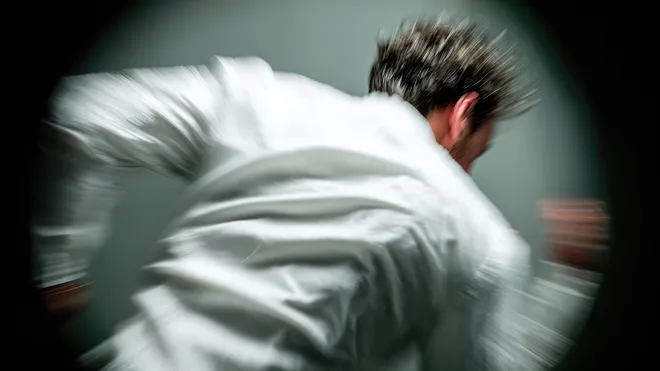 Figure in motion against a dark backdrop, edges softly blurred