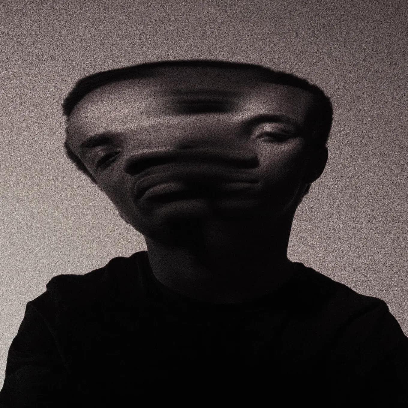 Softly blurred portrait of a figure holding still in muted light